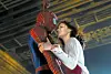 Spiderman holder Kirsten Dunst tæt i en dramatisk scene under en storbybro.