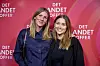 Mette Sommer og Helena Witt poserer foran en rød væg med teksten 'Det andet offer'.