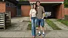 Josefine og Lasse står smilende foran et rødt murstenshus med carport.
