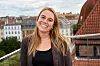 Alexandra Mosholt Søgaard på tagterrasse med røde tegltage i baggrunden