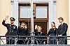 Norsk kongefamilie i sorte sørgedragter vinker fra en balkon i Oslo