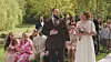 Frederik og Christina fra 'Gift ved første blik' står foran siddende gæster ved en udendørs vielse i grøn park.
