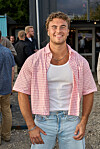 Asger smilende foran indgangen til Reality Awards sommerfest 2026 med gæster i baggrunden.