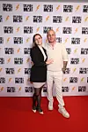 Mark Worsten poserer med sin forlovede på rød løber foran væg med 'Stupid Man'-logoer.