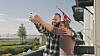 Par tager selfie på altan med norsk flag og udsigt over sø og grønt landskab
