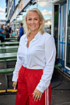 Cecilie Schmeichel står udendørs foran Pluto TV-arrangement i afslappet tøj.