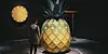 Person står i mørkt udstillingsrum foran stor skulptur formet som en ananas.