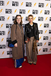 Julie Ølgaard på rød løber foran fotovæg ved premiere på “Stupid Man – The Musical”.