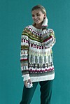 Model står i farverig julesweater foran turkis baggrund