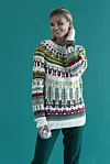 Model står i farverig julesweater foran turkis baggrund