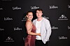 Melissa Bentsen med kæresten står tæt sammen foran sort Wallmans fotovæg ved event i København.