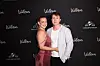Melissa Bentsen med kæresten står tæt sammen foran sort Wallmans fotovæg ved event i København.