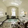 Lyst spa-rum med lille indendørs bassin, kurvemøbler og hvælvet loft