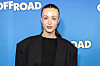 Person foran blå Off Road-væg ved filmpremiere