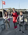 Tre personer går på havnemole ved VMD2016 med dansk flag i baggrunden.