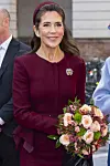 Dronning Mary i bordeauxdragt holder en buket blomster ved ankomsten til Christiansborg