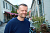 Frank Hvam står smilende i en brostensgade med caféer og cykler i baggrunden.