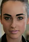 Model med markante mørke øjenbryn og rosa makeup backstage ved modeuge i Sydney.