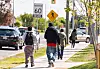 Unge går på fortov i Toronto ved vej med 60 km/t og fodgængerskilt.