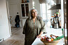 Anne Herdorf står eftertænksomt ved køkkenbord i lyst, moderne hjem
