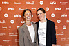Lise Rønne og Ditte Haue smiler foran orange 'Vild med dans'-væg med sponsorlogoer