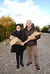 Janus Nielsen og ledsager står på en brostensvej med indpakkede blomsterbuketter.