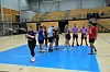 Spillere i sportshal står samlet på blå floorballbane efter kamp