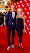 Carla Mickelborg og kæresten Carl Tellerup står smilende på den røde løber ved ZULU Comedy Galla 2022.