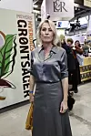 Kvinde i gråt tøj står foran Meyers Hverdagsgrøntsager-stand på en messe.