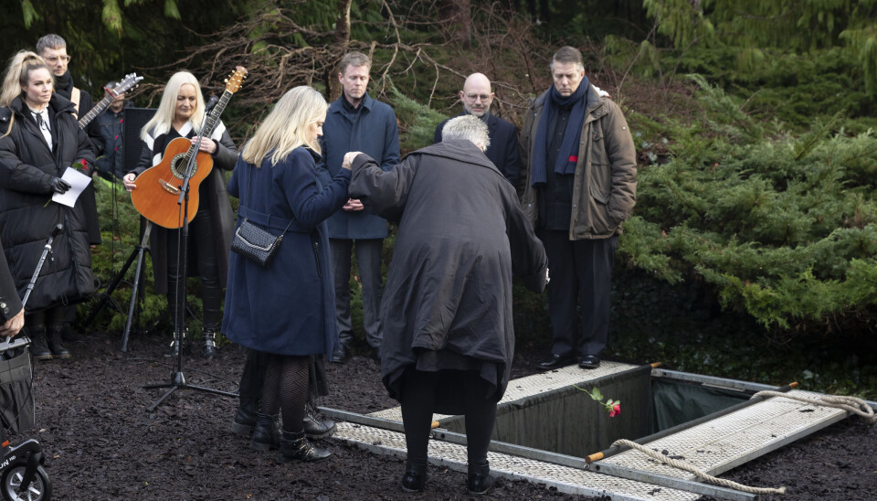 Ritts lillesøster, Guri, kaster en rose på kisten i graven. (Foto: Lars E. Andreasen)
